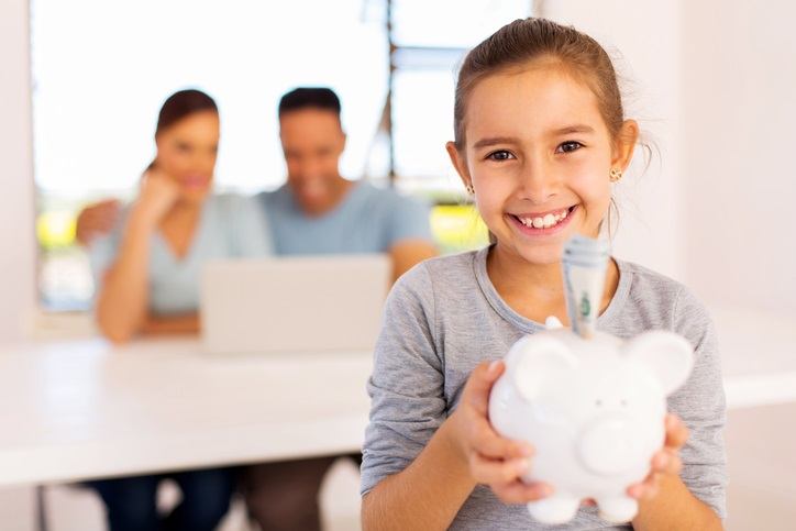 Little girl holding piggy bank