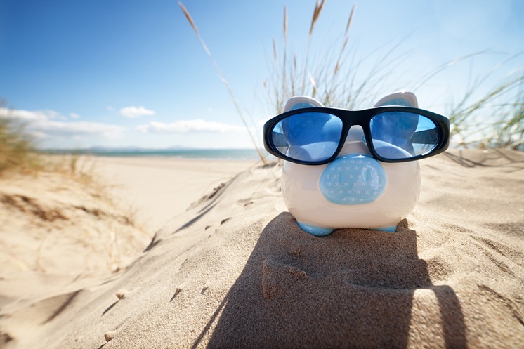 Piggy bank on beach _ How to Create a Travel Budget Blog Image